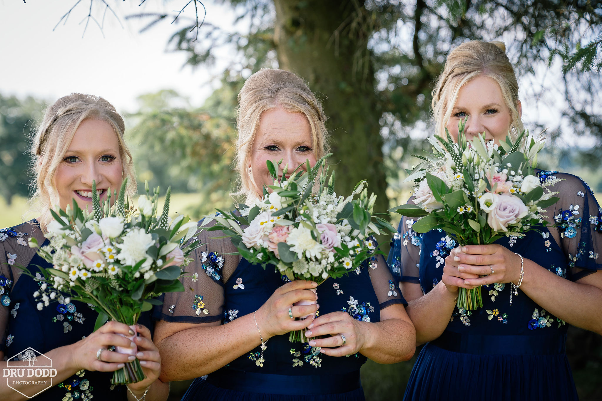 Bridesmaids with bouquets held high
